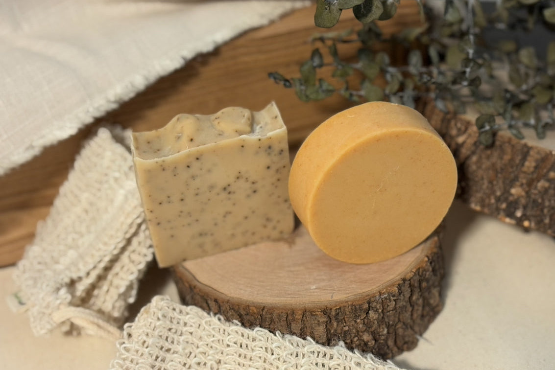 Two soap bars on a wooden surface with a natural background. West Grove Soaps handmade natural soap collection and eco-friendly bath products.